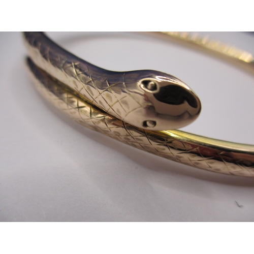 62 - A vintage yellow gold forearm bangle in the shape of a coiled snake, approx. weight 13.45g, having s... 