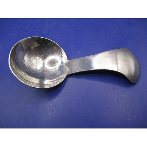 187 - An Arts & Craft hand beaten stainless steel caddy spoon with K.S.I.A mark for Keswick to back, in go... 