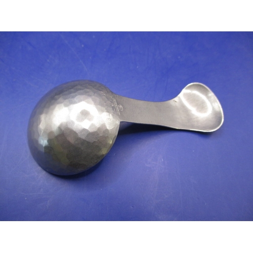 187 - An Arts & Craft hand beaten stainless steel caddy spoon with K.S.I.A mark for Keswick to back, in go... 