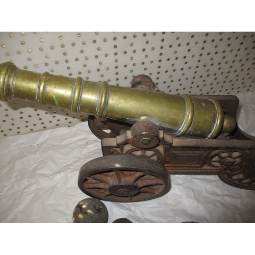 296 - A vintage brass and iron table top cannon and a quantity of iron balls, all in used condition, appro... 