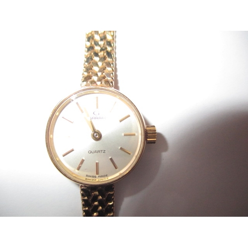 84 - A 9ct yellow gold ladies wrist watch with integral gold strap, marked Garrard, in original box, requ... 