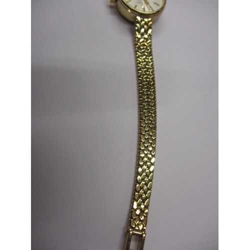 84 - A 9ct yellow gold ladies wrist watch with integral gold strap, marked Garrard, in original box, requ... 