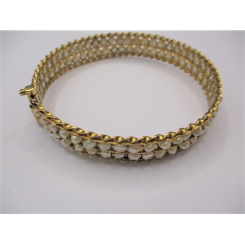 62 - A Bahrain gold and natural seed pearl bangle, clasp pin is stiff, approx. gross weight 19.4g, in vin... 