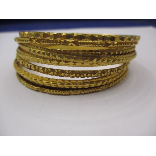 63 - Bahrain gold bangles, 9 in total, all different designs and widths, approx. gross parcel weight 99.7... 