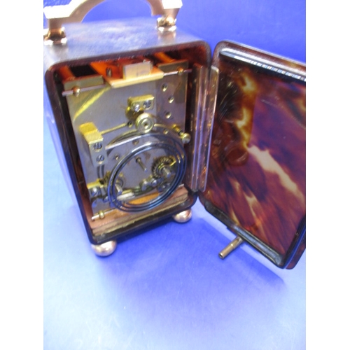 185 - An antique travel clock with hallmarked gold mounts, in current working order striking the hours. Ap... 