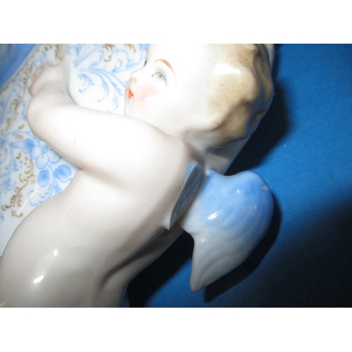 318 - A pair of vintage porcelain wall pockets, with blue swags, ribbons and cherubs, some damages but dis... 