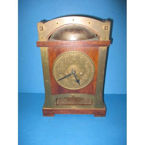 285 - An early 20th century Arts & Craft mantle clock, striking on a  bell with oak and brass body, with k... 