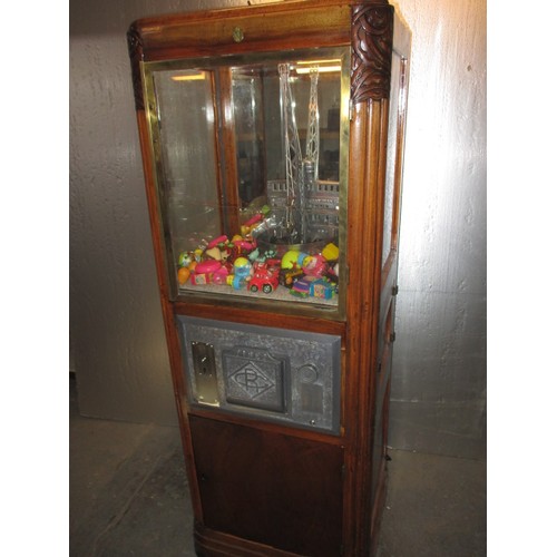 298 - A vintage coin operated grab crane arcade machine, being a continental model, in current working ord... 