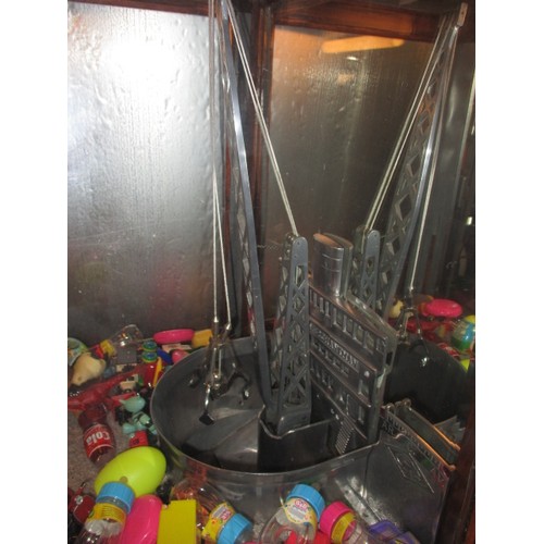 298 - A vintage coin operated grab crane arcade machine, being a continental model, in current working ord... 