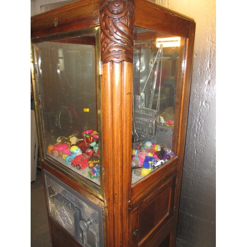 298 - A vintage coin operated grab crane arcade machine, being a continental model, in current working ord... 