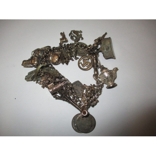 143 - A vintage sterling silver charm bracelet, to include a Victorian coin charm, approx. weight 85.9g, i... 