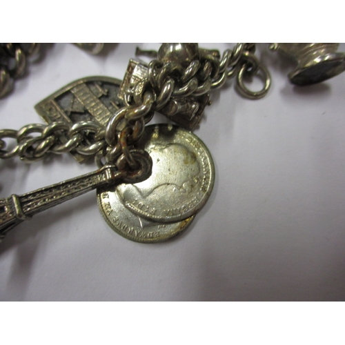 143 - A vintage sterling silver charm bracelet, to include a Victorian coin charm, approx. weight 85.9g, i... 