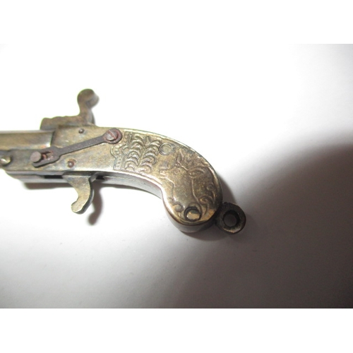 145 - A vintage white metal pistol charm with working mechanism and a decorative plated trowel, in useable... 