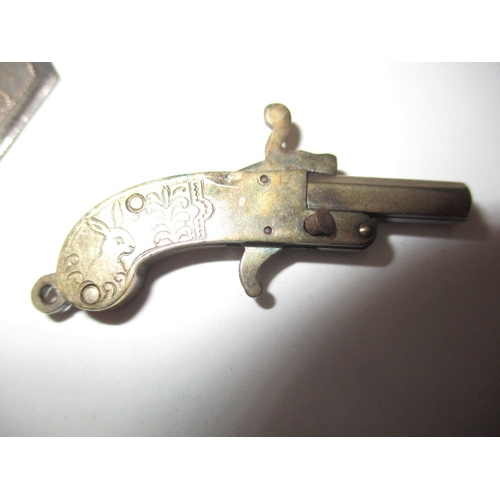 145 - A vintage white metal pistol charm with working mechanism and a decorative plated trowel, in useable... 