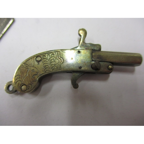 145 - A vintage white metal pistol charm with working mechanism and a decorative plated trowel, in useable... 