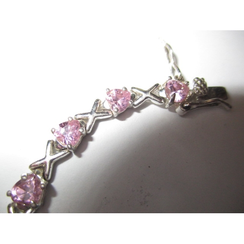 147 - A silver and pink stone hearts and kisses bracelet, approx. linear length 18cm, in useable pre-owned... 