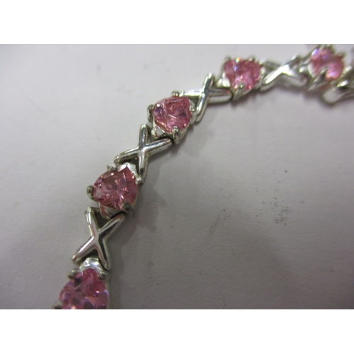 147 - A silver and pink stone hearts and kisses bracelet, approx. linear length 18cm, in useable pre-owned... 