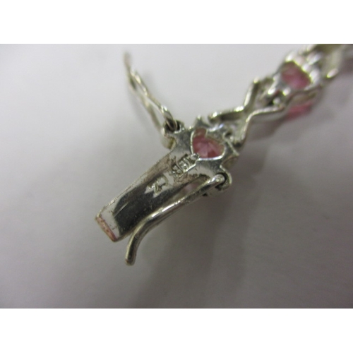 147 - A silver and pink stone hearts and kisses bracelet, approx. linear length 18cm, in useable pre-owned... 