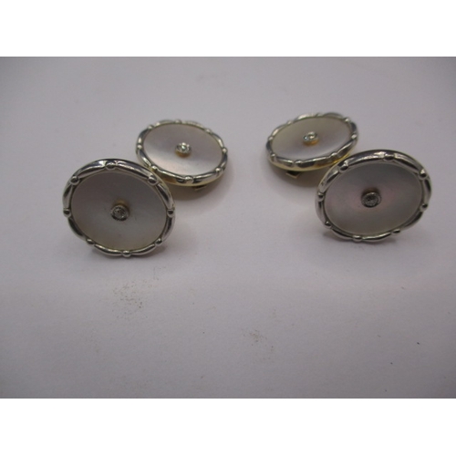 74 - A pair of 585ct gold cufflinks with mother of pearl panel and a small central diamond to each face, ... 