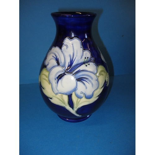 A Moorcroft vase in the Hibiscus design, approx. height 20cm high, in good pre-owned condition with no observed damage or restoration