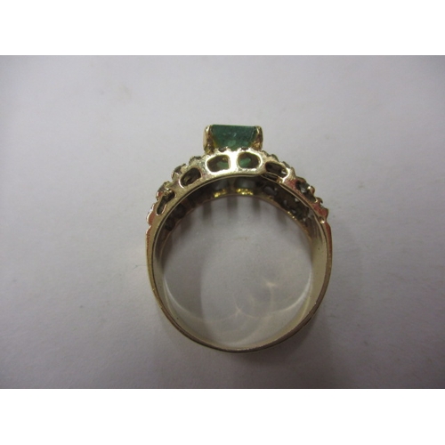 32 - A vintage yellow gold ring with central emerald flanked by numerous diamonds, approx. ring size ‘M+’... 