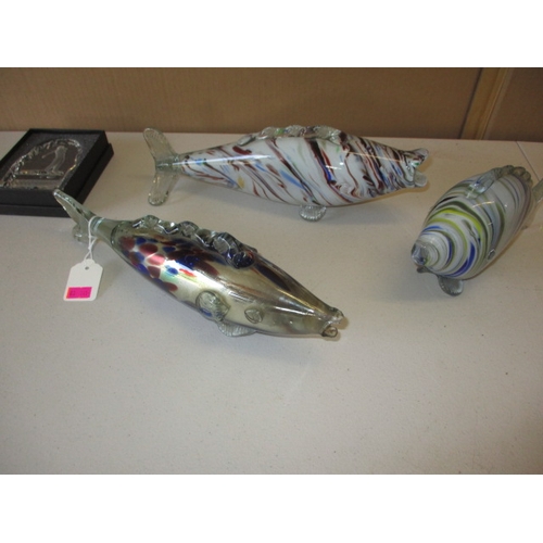 Three vintage glass fish, approx. length of longest 32cm, all in used condition with no observed damage, and a glass golfing paperweight