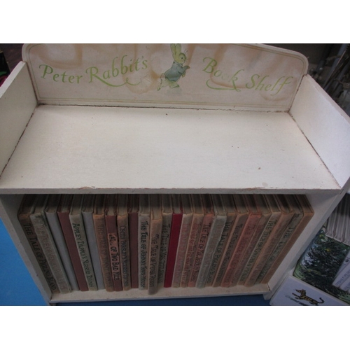 201 - A miniature wood bookcase with contents of Beatrix Potter books in well used condition and a boxed s... 