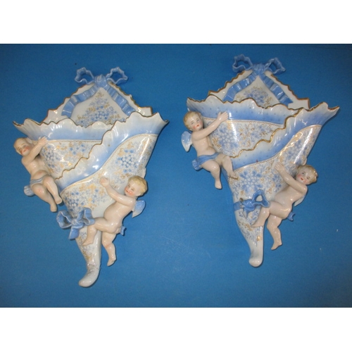 205 - A pair of vintage porcelain wall pockets, with blue swags, ribbons and cherubs, some damages but dis... 