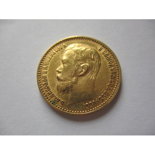 83 - A Russian gold five rouble coin, with Nicholas II dated 1899,  a circulated coin with very fine defi... 