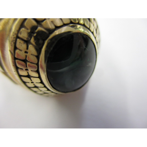 9 - An American 10k yellow gold college ring, the central green stone being cracked, approx. ring size ‘... 