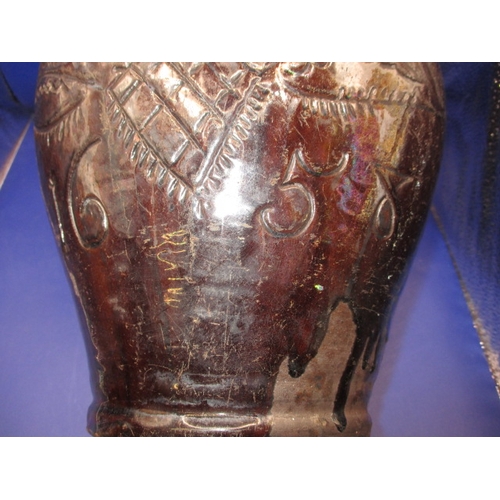 184 - An antique treacle glazed water jug having incised organic form decoration with date of 1658, approx... 