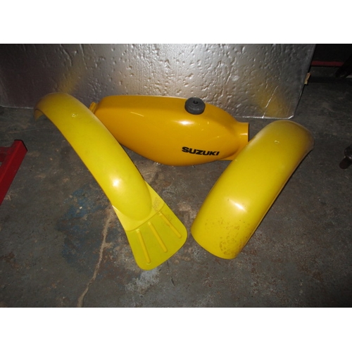 225 - A Suzuki competition fibre glass petrol tank and front and rear guards, look to be in unused conditi... 