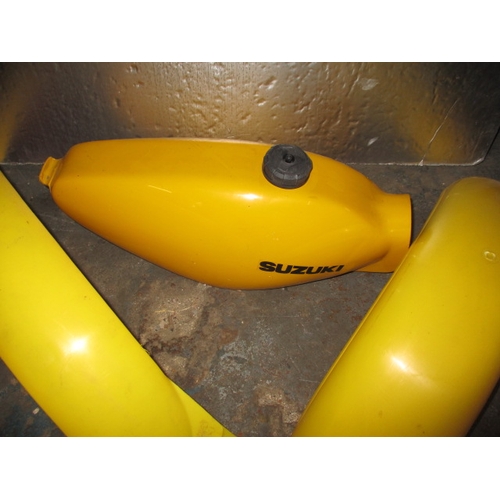 225 - A Suzuki competition fibre glass petrol tank and front and rear guards, look to be in unused conditi... 