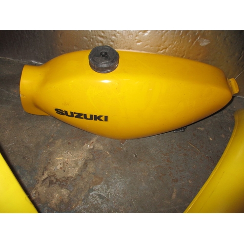 225 - A Suzuki competition fibre glass petrol tank and front and rear guards, look to be in unused conditi... 