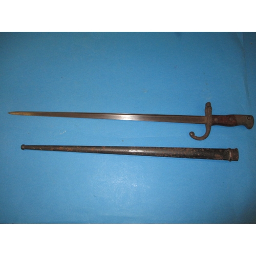 An antique French bayonet, dated 1877, with scabbard, approx. length 64cm, in good pre-owned condition