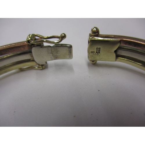 44 - A 9ct tri-colour gold bangle, approx. weight 14g, clasp opening clip broken