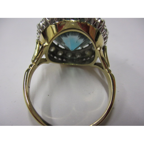 11 - An 18ct yellow and white gold blue zircon and diamond dress ring, set with a central 14mm round blue... 