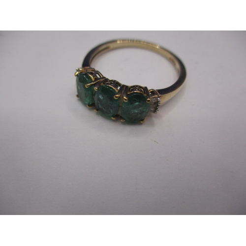 14 - A 9ct yellow gold, 3 stone Zambian emerald dress ring with diamond set shoulders, approx. ring size ... 