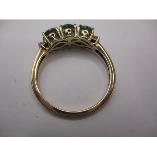 14 - A 9ct yellow gold, 3 stone Zambian emerald dress ring with diamond set shoulders, approx. ring size ... 