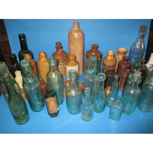 228 - A collection of antique and later glass and stoneware bottles, various makers, some local, all in us... 