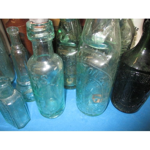 228 - A collection of antique and later glass and stoneware bottles, various makers, some local, all in us... 