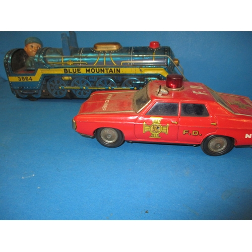 248 - A vintage Japanese tin plate fire chief car, being battery operated and a tin plate train, bell miss... 