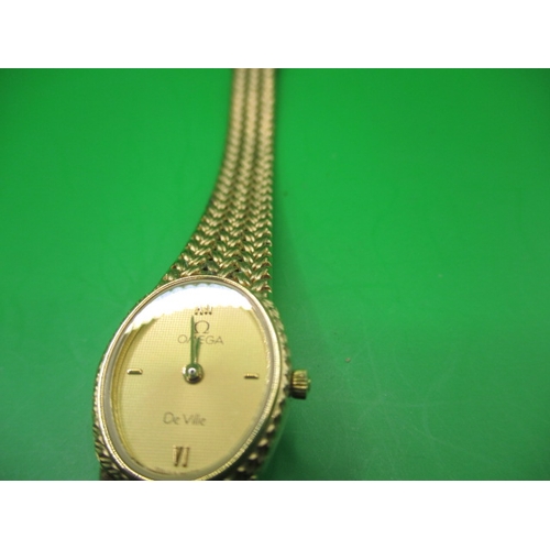 100 - A vintage ladies Omega De Ville watch with integral yellow metal strap, in pre-owned condition and n... 