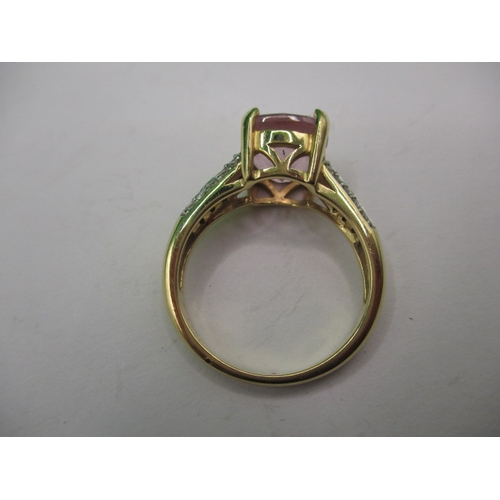 6 - An 18ct yellow gold dress ring with central pink stone and diamond set shoulders, approx. ring size ... 