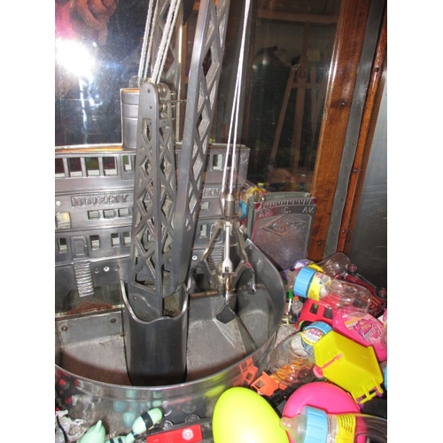 91 - A vintage coin operated grab crane arcade machine, being a continental model, in current working ord... 