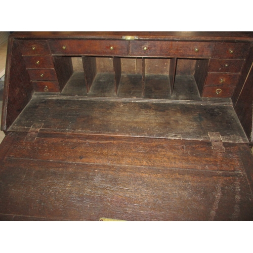 116 - An antique oak bureau with manual loapers and 4 long graduated drawers. Age related marks and repair... 