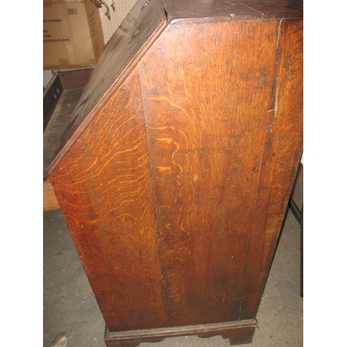 116 - An antique oak bureau with manual loapers and 4 long graduated drawers. Age related marks and repair... 