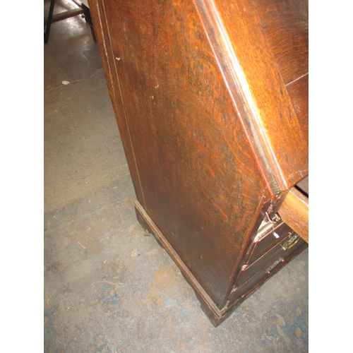 116 - An antique oak bureau with manual loapers and 4 long graduated drawers. Age related marks and repair... 