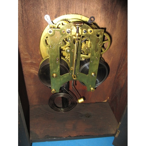 211 - A vintage American made oak cased mantle clock, with key and pendulum, runs when wound but would ben... 