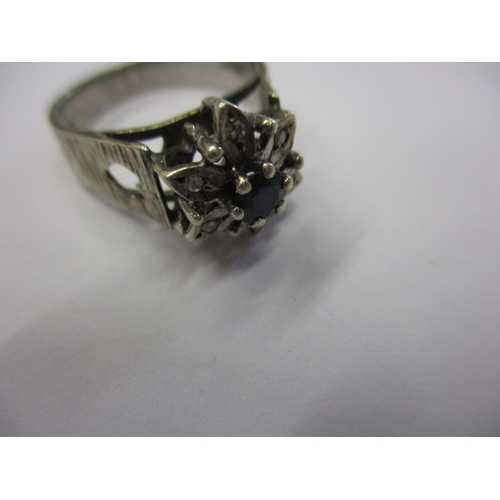 22 - A 9ct white gold cluster ring, having diamonds round a central blue stone, approx. ring size ‘M+’ ap... 